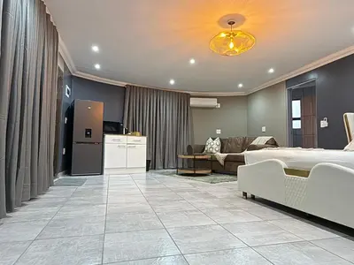 a bedroom with a bed and a living room at Yinjwasi Hill guest house in Armburg