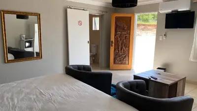 a room with a table and chairs and a mirror at Yinjwasi Hill guest house in Armburg