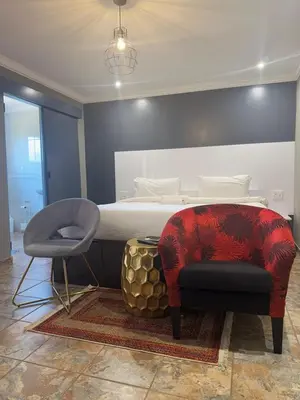 a bedroom with a bed and a chair at Yinjwasi Hill guest house in Armburg