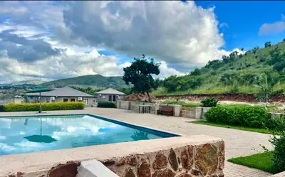 a swimming pool in the middle of a yard at Yinjwasi Hill guest house in Armburg
