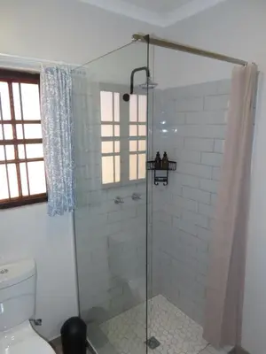a shower with a glass door in a bathroom at Around the corner in Pretoria
