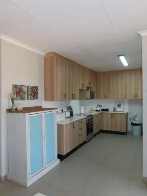 a large kitchen with wooden cabinets and appliances at Around the corner in Pretoria