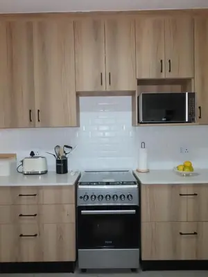 a kitchen with a stove and a microwave at Around the corner in Pretoria