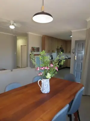a vase of flowers sitting on a wooden table at Around the corner in Pretoria