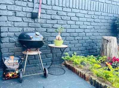 a grill on a stand next to a brick wall at Wapadrand Modern Self-catering Apartment in Pretoria