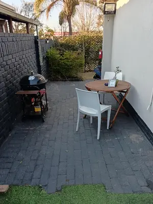 a patio with a table and chairs and a grill at Wapadrand Modern Self-catering Apartment in Pretoria