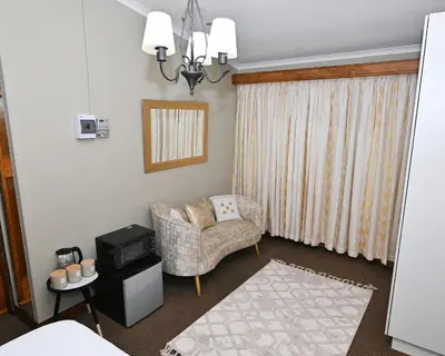 a living room with a chair and a window at Morning Star Guest House in Kempton Park