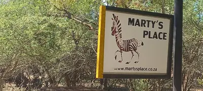 a sign for a marriott place with a zebra on it at Martys Place in Marloth Park