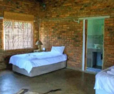 a bedroom with a bed and a brick wall at Harnham Mountain Lodge in Elsteg