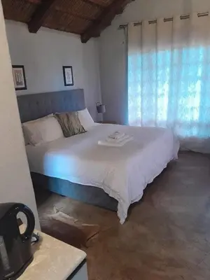 a bedroom with a large white bed with a window at Harnham Mountain Lodge in Elsteg