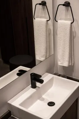 a bathroom with a white sink and a mirror at Menlyn Maine Trilogy Apartment in Pretoria