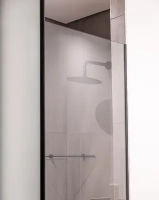 a glass door with a shower with a lamp on it at Menlyn Maine Trilogy Apartment in Pretoria