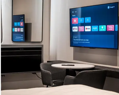 a room with a tv and a chair and a table at Menlyn Maine Trilogy Apartment in Pretoria