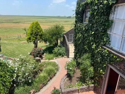 a house with a garden next to a building at Doringdraad Lodge Room Rafiki in Brendan Village