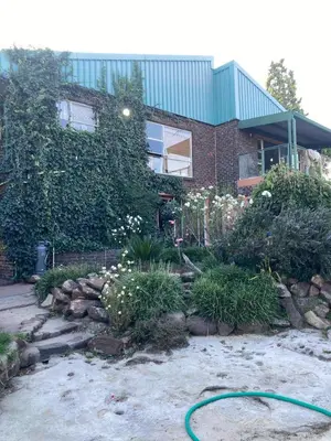a house with a hose in front of a garden at Doringdraad Lodge Room Rafiki in Brendan Village