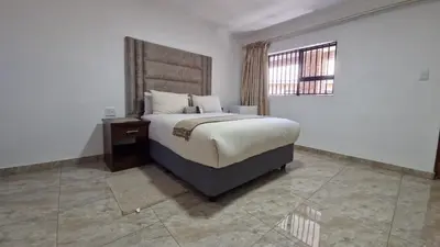 a bedroom with a large bed and a window at 7th Heaven Boutique Hotels in Burgersfort