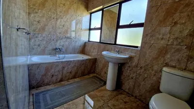 a bathroom with a tub and a sink and a toilet at 7th Heaven Boutique Hotels in Burgersfort