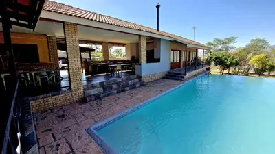 a large swimming pool in front of a house at 7th Heaven Boutique Hotels in Burgersfort