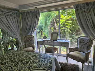a bedroom with a bed and a desk with a computer at Villa at 185 Milner Street in Pretoria