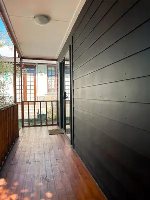 a room with a wooden floor and a balcony at The Shed - Capital Park in Pretoria