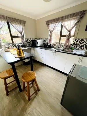 a kitchen with a table and chairs in a room at The Shed - Capital Park in Pretoria
