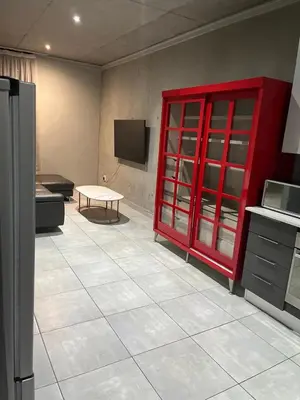 a kitchen with a red cabinet and a tv at 124 Brooks in Pretoria