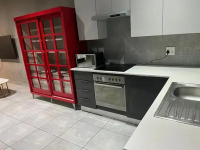 a kitchen with a stove and a red cabinet at 124 Brooks in Pretoria