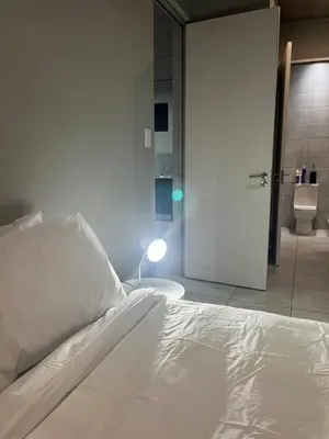 a bedroom with a bed and a bathroom with a toilet at 124 Brooks in Pretoria