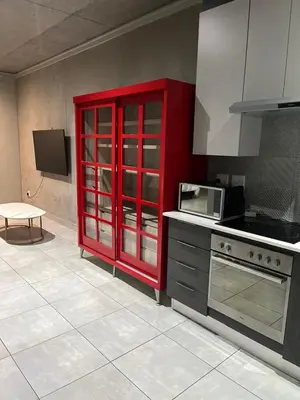 a kitchen with a red cabinet and a stove at 124 Brooks in Pretoria