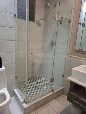 a shower with a glass door in a bathroom at 124 Brooks in Pretoria
