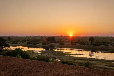 a sunset over a river in the desert at Sajema River Lodge in Hectorspruit
