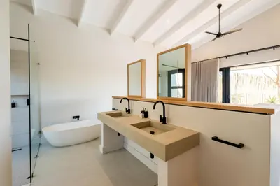 a bathroom with a sink and a tub and a mirror at Sajema River Lodge in Hectorspruit