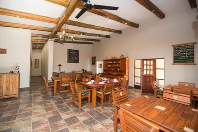 a dining room with wooden tables and chairs at Foreva Wild in Klipdrift