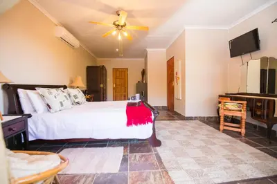 a bedroom with a large bed and a ceiling fan at Foreva Wild in Klipdrift