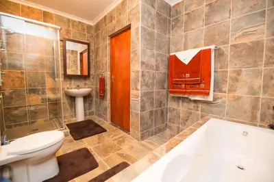 a bathroom with a tub and a toilet and a sink at Foreva Wild in Klipdrift