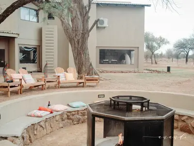 a fire pit in front of a house with a tree at Foreva Wild in Klipdrift