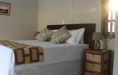a bedroom with a bed with white sheets and pillows at Foreva Wild in Klipdrift