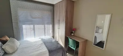 a bedroom with a bed and a window with a mirror at Ekuhlaleni a home away from home R7 in Pretoria