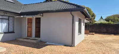 a small white house with a door in a driveway at Ekuhlaleni a home away from home R7 in Pretoria