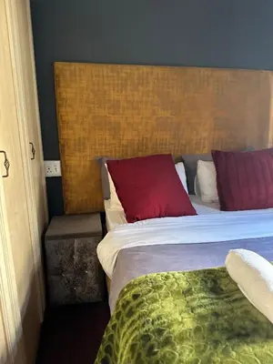 a bedroom with a bed with a red pillow at Crown Guesthouse-Waterkloof in Pretoria