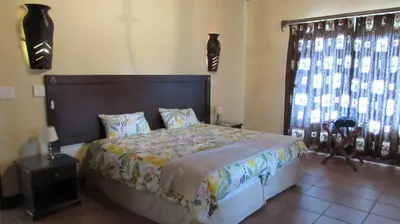 a bedroom with a large bed and a window at 205 Zebula 2 bedroom cottage in Warmbaths