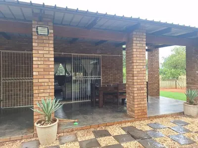 a patio with a fence and a wooden table at Oppieplaas in Alldays