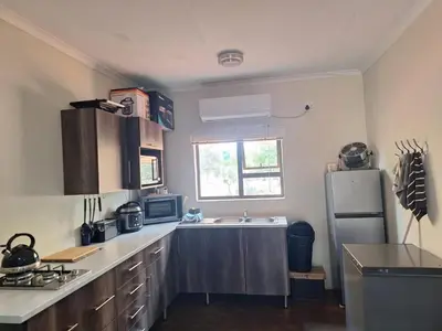 a kitchen with a sink and a refrigerator at Oppieplaas in Alldays