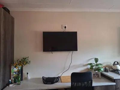 a living room with a television on a wall at Oppieplaas in Alldays