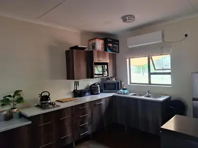 a kitchen with wooden cabinets and a sink at Oppieplaas in Alldays