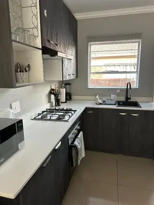 a kitchen with a sink and a stove top oven at The Olive Nook 2-Bed in Midrand in Midrand
