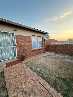 a brick house with a clock on the side of it at The Olive Nook 2-Bed in Midrand in Midrand