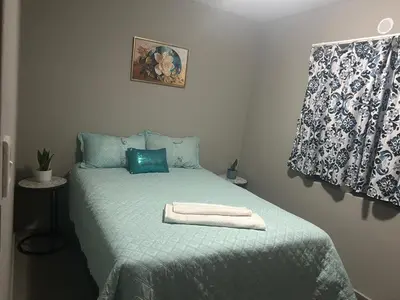 a bedroom with a green bed with a towel on it at Peaceful Cute Apartment in Pretoria