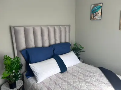a bed with blue and white pillows in a room at Peaceful Cute Apartment in Pretoria