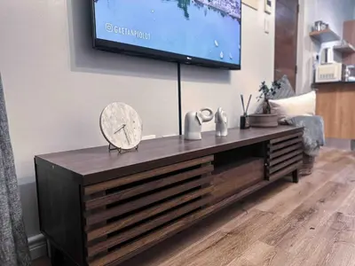 a living room with a television on a wall at A home away from home cosy luxurious compact 1 bed in Centurion